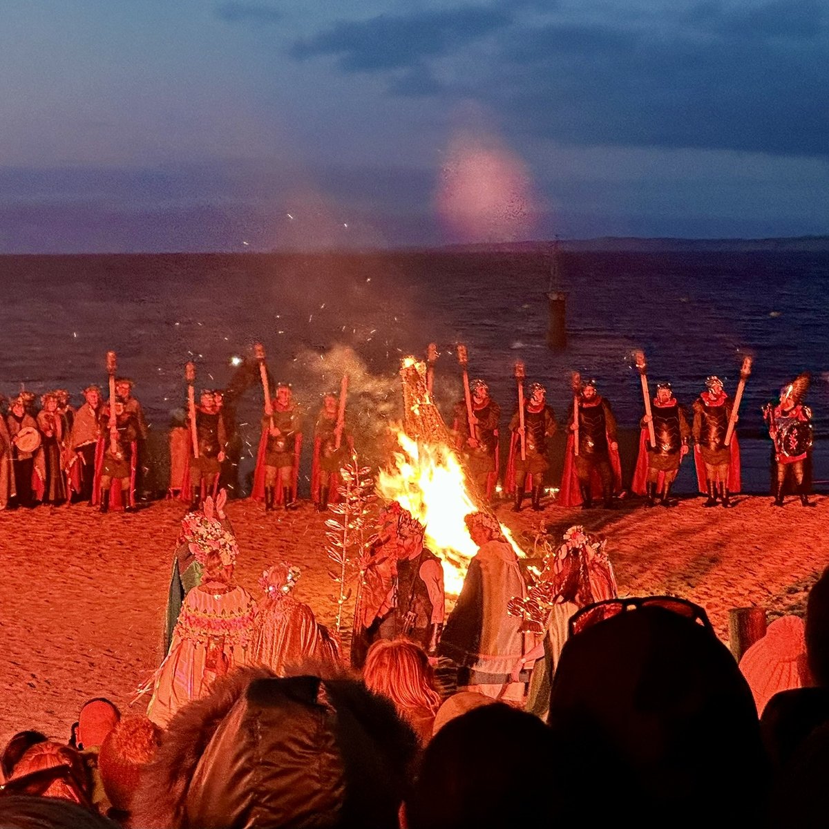 Viking and traditional costumes around the beach bonfire