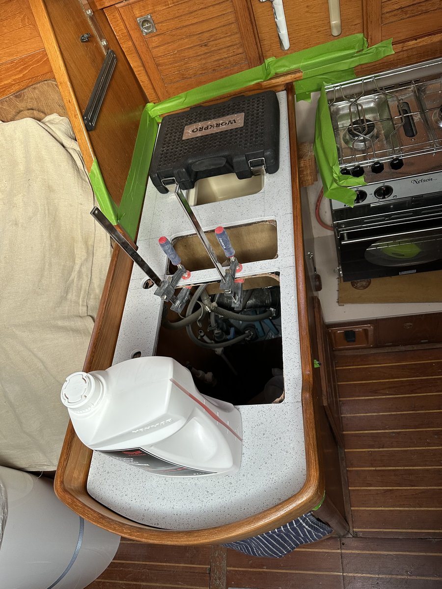 Galley with open engine access panel and maintenance tools