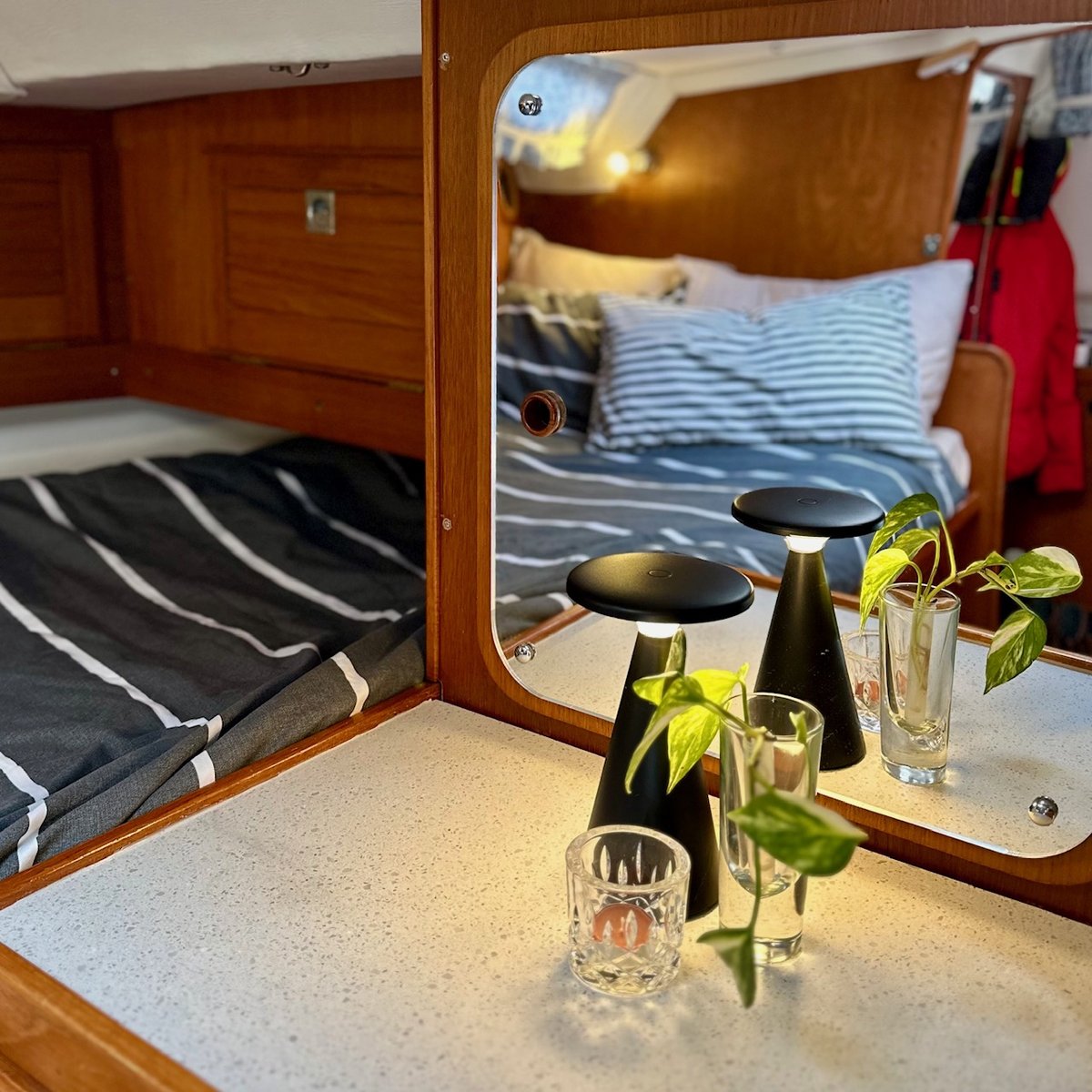 Aft cabin - plants, blue bedding, and a mirror that stays put at sea