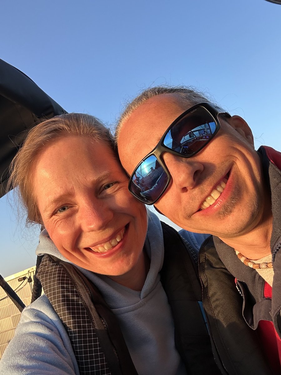 Rob and Andrea smiling on deck in the warm light