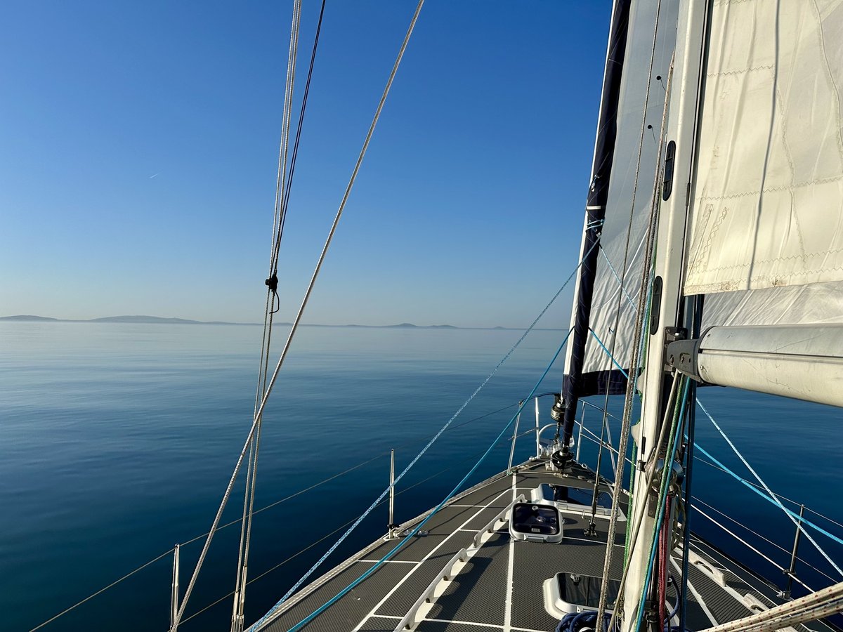 Heading towards the Lleyn Peninsula - bow view, sail up, distant coastline ahead