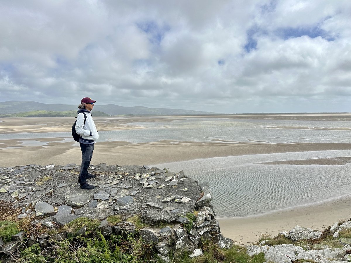Rob on rocky outcrop overlooking beach and mountains
