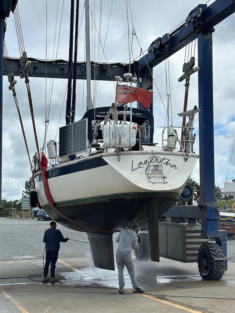 Hull being pressure-washed in the slings