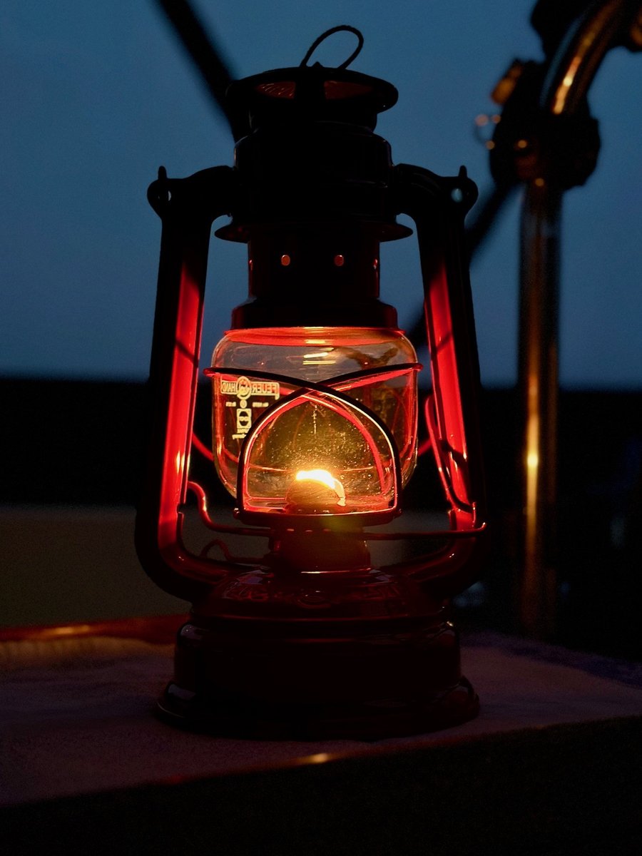 Cozy night at anchor - lantern glowing in the cockpit