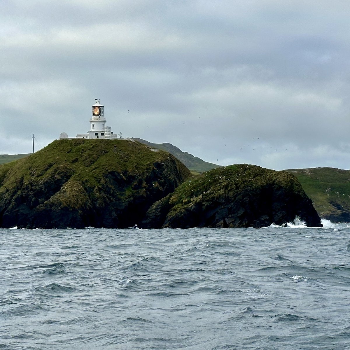 Strumble Head Lighthouse on a rocky island in choppy seas