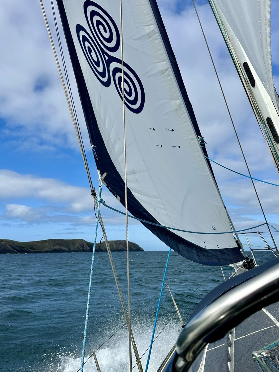 Beating towards St Davids - the triskelion sail against blue sky