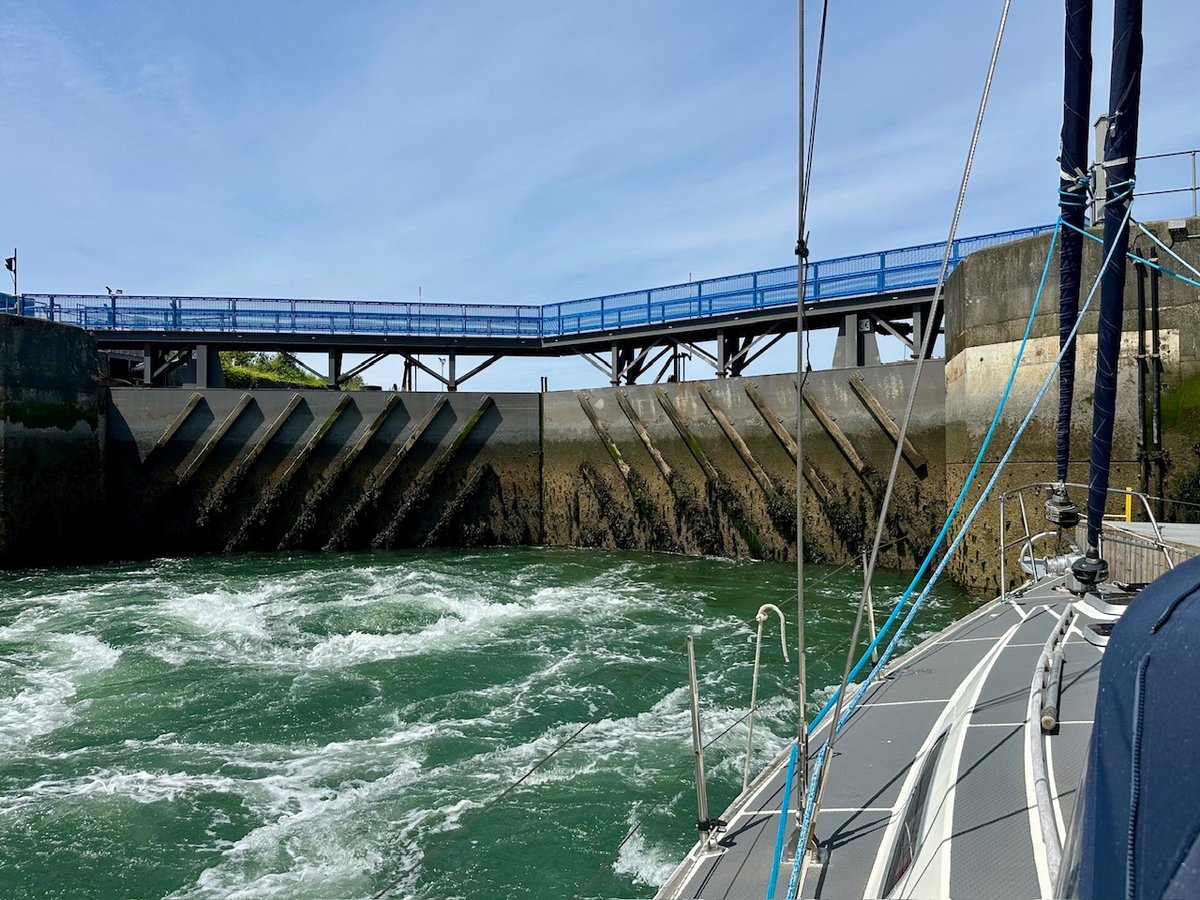 Milford Haven Marina lock with churning green water and blue walkway