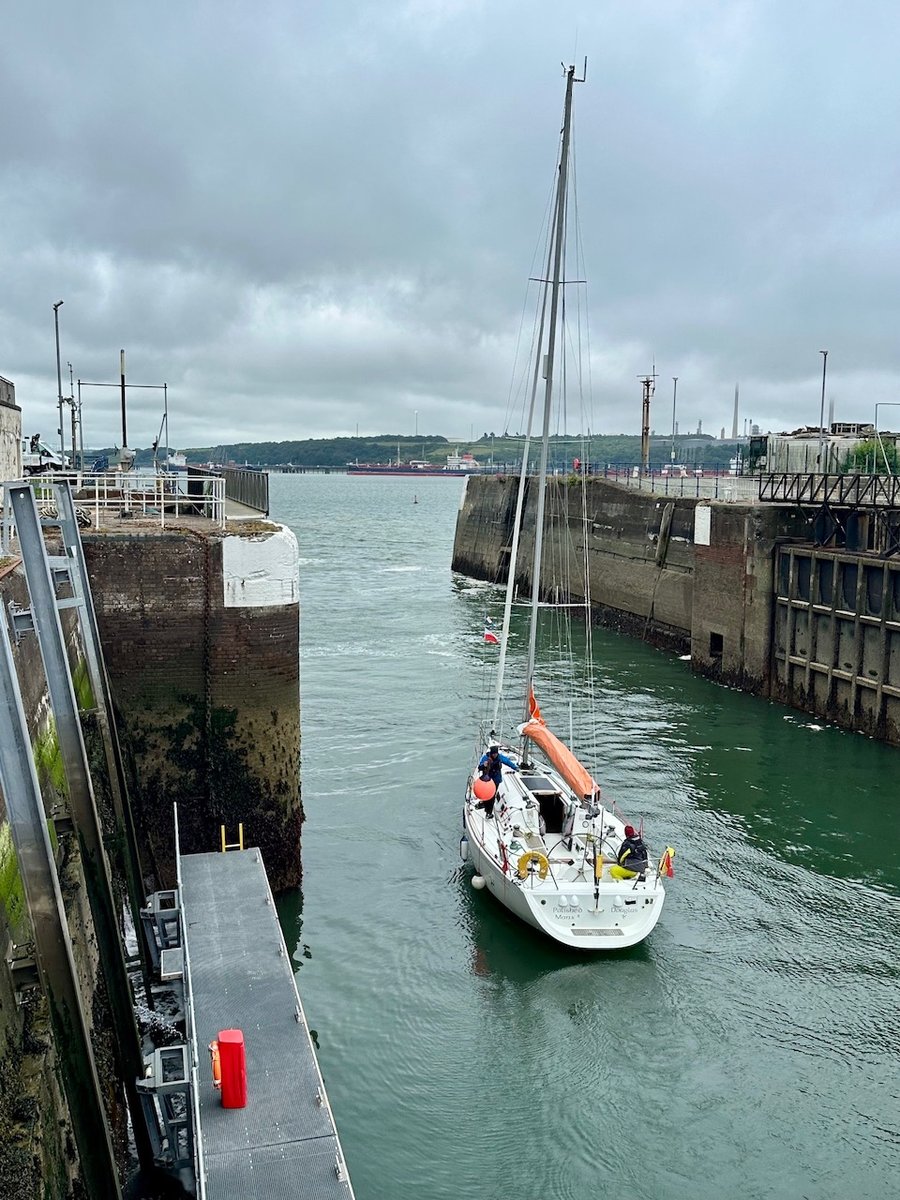 Waving Polished Manx 2 goodbye - sailboat in narrow concrete channel under overcast sky