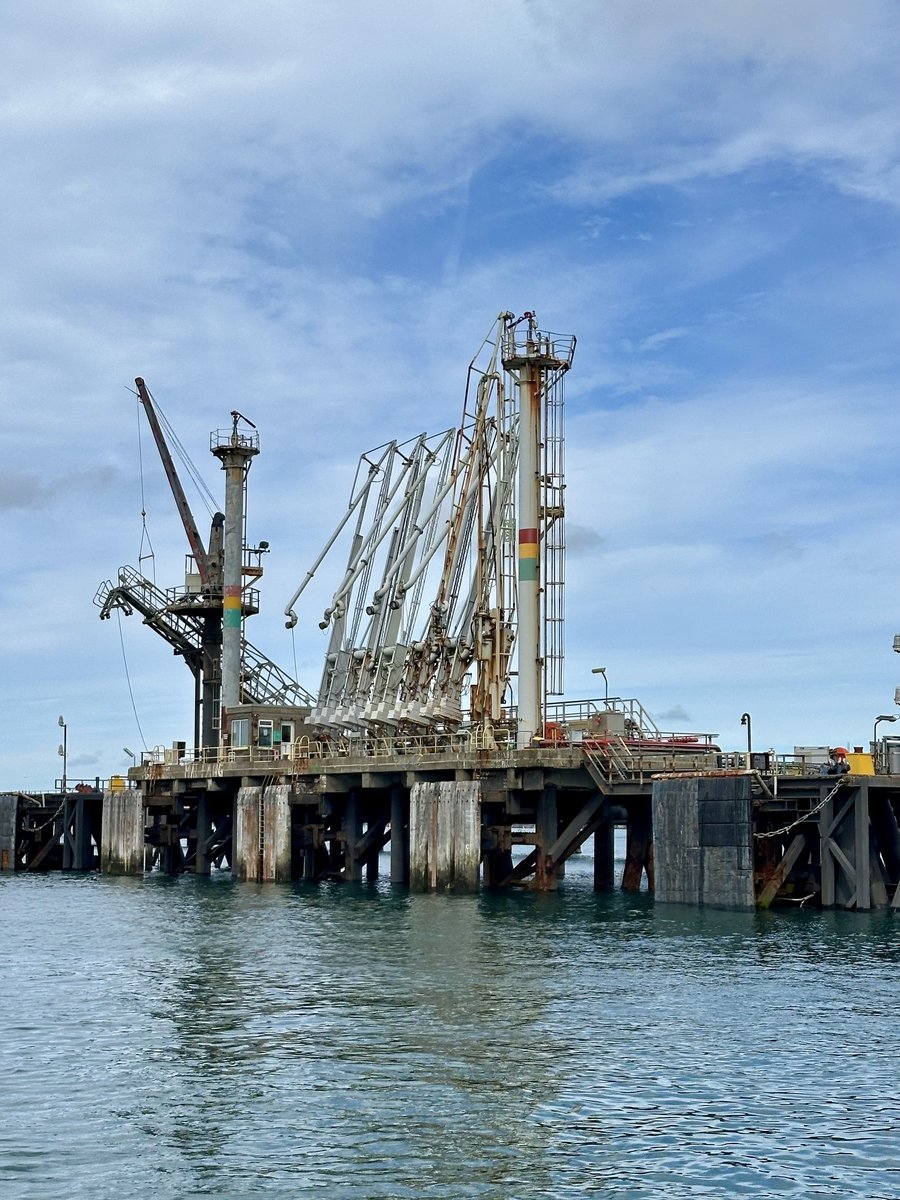 Milford Haven oil and gas terminal - industrial pier with cranes against blue sky