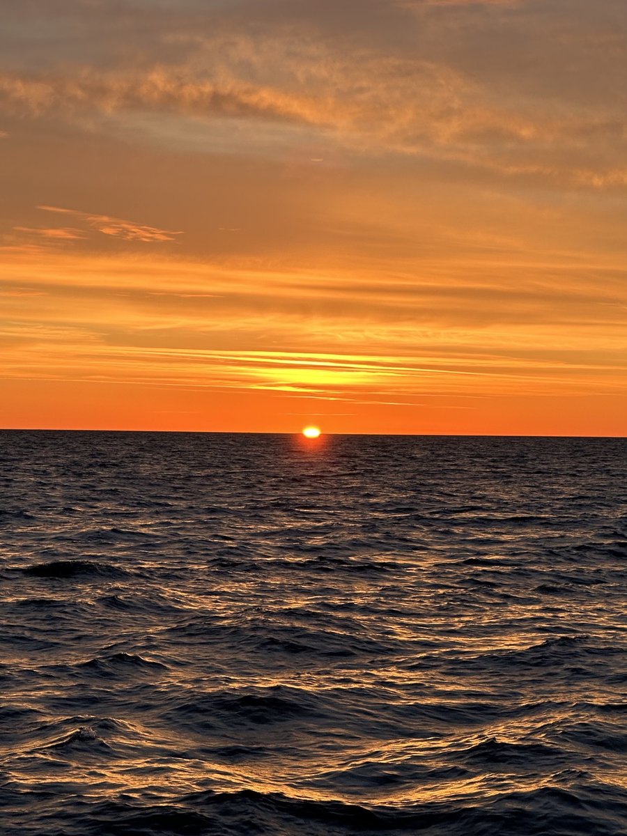 Sunrise over the ocean - sun on the horizon, warm orange sky