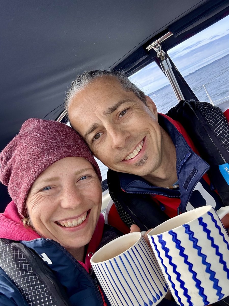 Rob and Andrea with coffees in the cockpit, warm and cosy