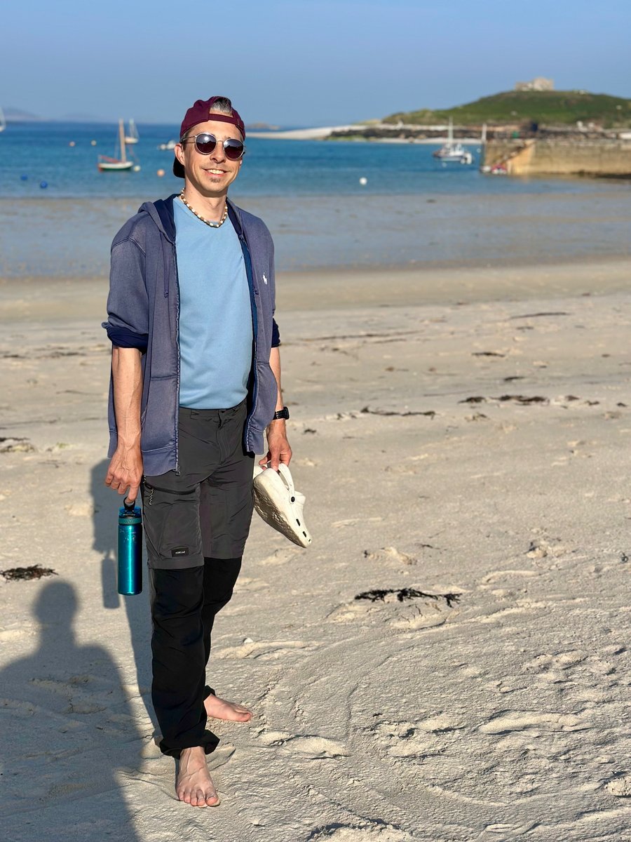Rob on the white sand beach at Old Grimsby, sailboats at anchor