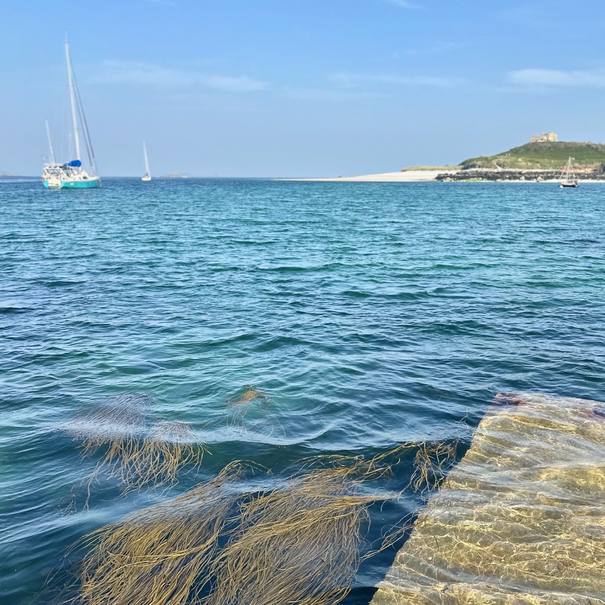 Old Grimsby anchorage - sailboat at anchor, turquoise water, stone tower on the hill