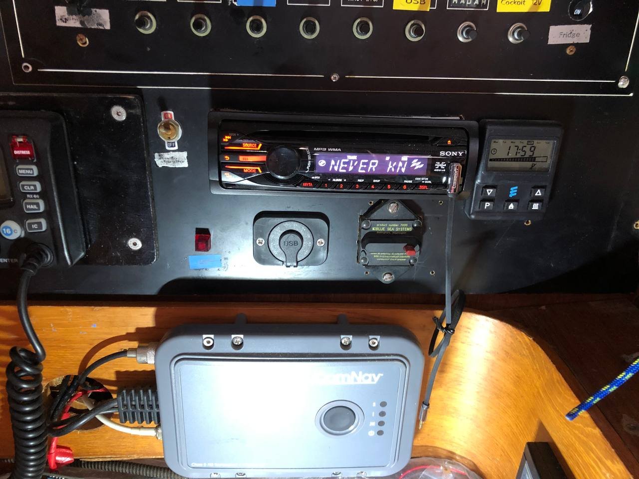 Old nav station with Sony car stereo, ICOM VHF, and tangled wiring behind the panel