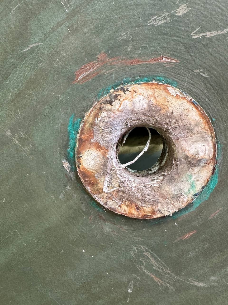 Close-up of a heavily corroded through-hull fitting showing pitting and metal loss